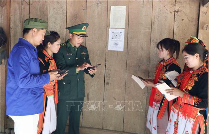 Cán bộ, chiến sĩ Đồn Biên phòng cửa khẩu Ma Lù Thàng (Lai Châu) hướng dẫn người dân quyét mã hòm thư ẩn danh. Ảnh: Nguyễn Oanh - TTXVN